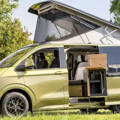 Camping-car vert avec toit relevable et cuisine extérieure. Innovations transports camping car pour l'aventure.
