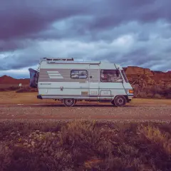 Camping-car Hymer B544, prêt pour l'aventure dans un paysage désertique sous un ciel orageux.