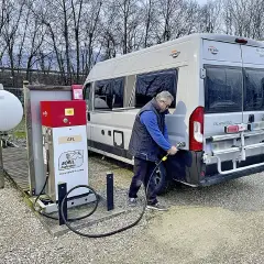 Un homme fait le plein de son camping-car à une pompe GPL. Le bon gaz pour camping car est le GPL.