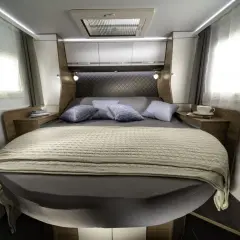 Lit transversal confortable dans un camping-car, prêt pour une nuit paisible.