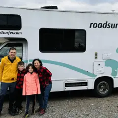 Famille souriante devant un camping-car Roadsurfer prêt pour un road trip Canada. L'aventure commence !