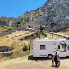 Une famille en camping-car devant une ancienne citadelle. Leur tour du monde camping car les mène vers des sites historiques incroyables.
