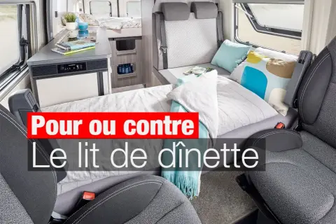Aménagement intérieur d'un camping-car avec un lit de dînette transformé, prêt pour le repos.
