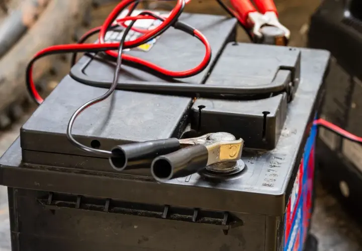 Pinces rouges et noires connectées à une batterie, prêt à savoir comment recharger les batteries d'un camping-car.