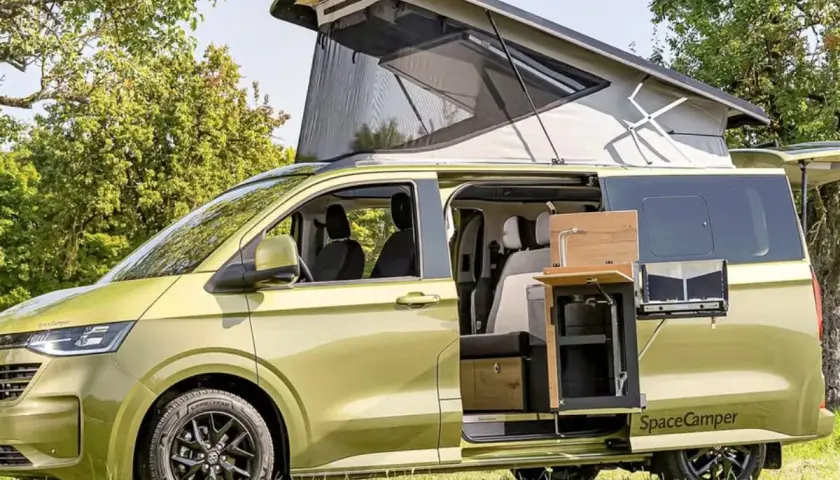 Camping-car vert avec toit relevable et cuisine extérieure. Innovations transports camping car pour l'aventure.