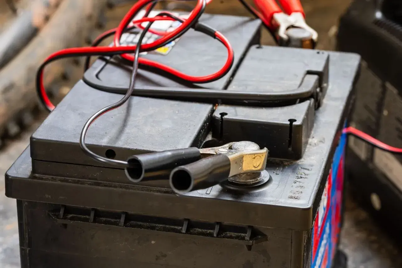 Pinces rouges et noires connectées à une batterie, prêt à savoir comment recharger les batteries d'un camping-car.
