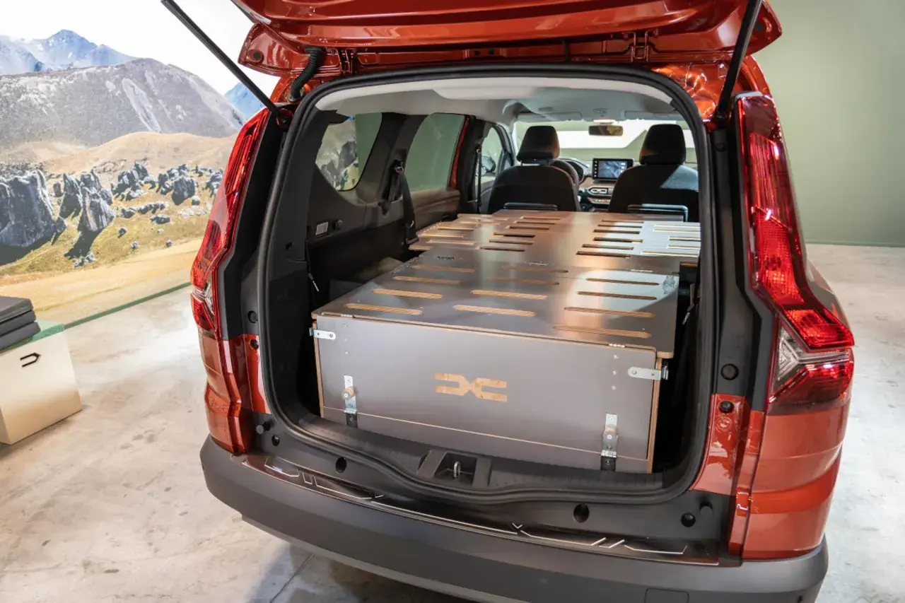 Aménagement intérieur d'un camping car Dacia, prêt pour l'aventure. Le coffre est aménagé avec un lit modulable, idéal pour les escapades.