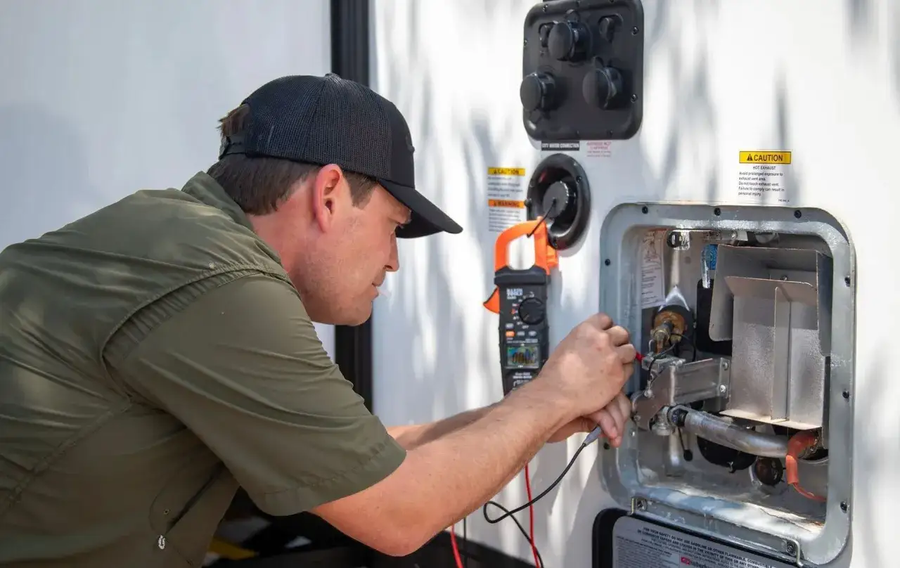 Un technicien v&eacute;rifie le chauffage Truma d'un camping-car. Le prix de l'entretien est une pr&eacute;occupation pour les propri&eacute;taires.