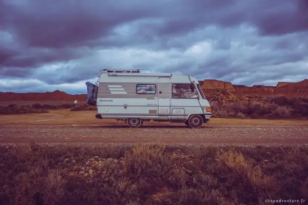 Camping-car Hymer B544, prêt pour l'aventure dans un paysage désertique sous un ciel orageux.